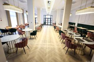 a large room with tables and chairs in a restaurant at Hotel IMPERIAL Campulung in Câmpulung