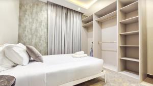 a bedroom with a white bed and shelves at Spacious 3 Bedroom Apartment in Al Muzāḩimīyah