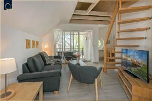 a living room with a couch and a tv at Ferienanlage Seeblick Meerchen in Ostseebad Koserow