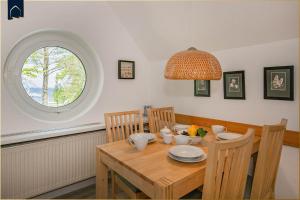 a dining room with a wooden table and a window at Ferienanlage Seeblick Meerchen in Ostseebad Koserow