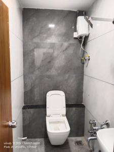 a bathroom with a toilet and a sink at Hotel Metro AC Room in Vadodara