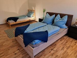 a bedroom with two beds with blue pillows at Ferienwohnung See und Sonne in Obing