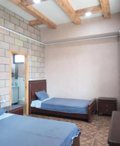 a bedroom with two beds and a brick wall at Eco guesthouse in Gerger +15 photos