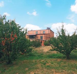 an old brick house on a hill with trees at Eco guesthouse in Gerger