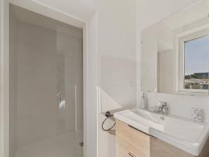 une salle de bain blanche avec un lavabo et un miroir dans l'établissement Vue rivière - Bel appartement avec balcon pour 8, à Saint-Gilles-Croix-de-Vie 16 autres photos