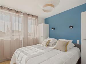 une chambre avec un grand lit blanc avec des murs bleus dans l'établissement Vue rivière - Bel appartement avec balcon pour 8, à Saint-Gilles-Croix-de-Vie