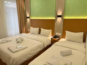Una habitación de hotel con dos camas con toallas. en Royal Pera Taksim, en Estambul