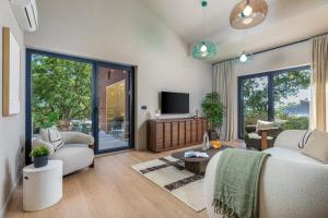 a living room with a couch and a tv at Villa Mol by Villsy - with private pool, sauna, jacuzzi in Baderna