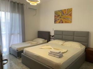 a bedroom with two beds with towels on them at Serenade Beach in Durrës