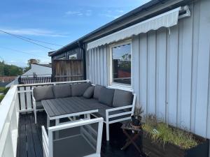 a patio with a bench and a table on a deck at Nesøya family house in Asker