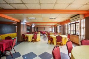 a dining room with tables and chairs and a chalkboard at Holiday Express Hotel Kampala in Kampala