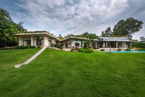 a house with a large yard and a pool at SaffronStays Swallow's Nest in Kolvan