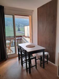 a dining room with a table and chairs and a balcony at Studio Superdevoluy 4 personnes au pied des pistes in Superdevoluy +15 photos