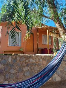 a hammock in front of a house at Cabaña valle de elqui horcon Encantó del pimiento in Horcon