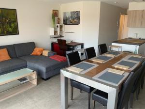 a living room with a table and a couch at La madeleine in De Panne