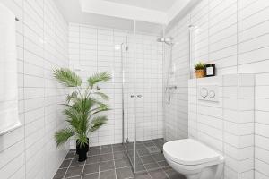 a bathroom with a toilet and a plant in it at Newly renovated 3 BedRm, Spacious 80m sq, comtemporary Apartment in Central Trendy Oslo-Grunnerlokka in Oslo