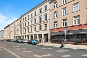 a street with cars parked in front of a building at Newly renovated 3 BedRm, Spacious 80m sq, comtemporary Apartment in Central Trendy Oslo-Grunnerlokka in Oslo