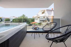 a balcony with two chairs and a swimming pool at Cataleya Apartments Makarska in Makarska
