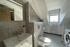 Un baño blanco con lavabo e inodoro. en Littoral Studio, en Le Havre