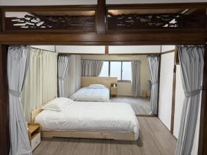 a bedroom with a bed and a large window at 旭の屋 in Osaka