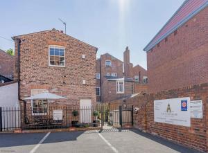 a brick building with a table and an umbrella at 4B City Cottages in Chester