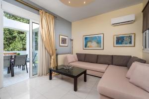 a living room with a couch and a table at Euphoria Villa up to 5 in Ialysos