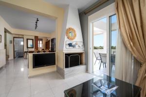 a living room with a tv and a fireplace at Euphoria Villa up to 5 in Ialysos