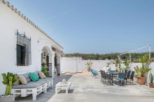 a patio with a couch and a table and chairs at Villa Castro in Vejer de la Frontera