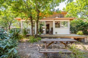 ein kleines Haus mit einem Picknicktisch davor in der Unterkunft Bungalow Californie 48 in Vendays-Montalivet