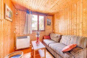 ein Wohnzimmer mit einer Couch und einem Fenster in der Unterkunft Bungalow Californie 48 in Vendays-Montalivet