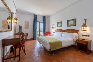 a bedroom with a bed and a desk and a desk at Moon Dreams El Cortijo in Matalascañas