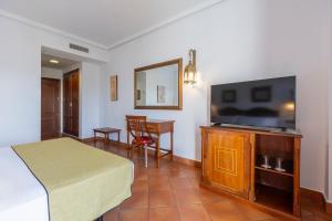 a hotel room with a bed and a flat screen tv at Moon Dreams El Cortijo in Matalascañas