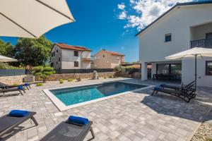 a swimming pool in the backyard of a house at Kuća za odmor TARA & LANA I in Kornić