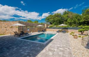 a pool with chairs and umbrellas in a yard at Kuća za odmor TARA & LANA I in Kornić