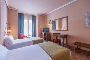 a hotel room with two beds and a mirror at Moon Dreams El Cortijo in Matalascañas