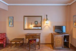 a room with a table and a tv and a mirror at Moon Dreams El Cortijo in Matalascañas