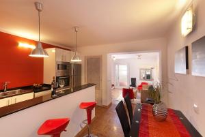 a kitchen and living room with red chairs and a table at Gruat 31 - Vallem Properties in Pollença
