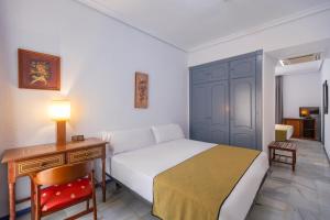 a bedroom with a bed and a table with a lamp at Moon Dreams El Cortijo in Matalascañas
