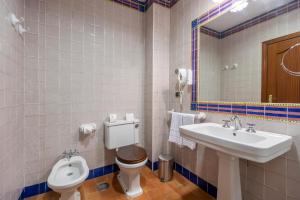 a bathroom with a sink and a toilet and a mirror at Moon Dreams El Cortijo in Matalascañas
