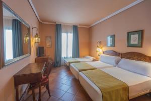 a hotel room with two beds and a desk at Moon Dreams El Cortijo in Matalascañas