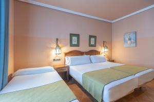 a hotel room with two beds and two lamps at Moon Dreams El Cortijo in Matalascañas