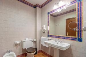a bathroom with a sink and a toilet and a mirror at Moon Dreams El Cortijo in Matalascañas