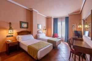a hotel room with two beds and a desk at Moon Dreams El Cortijo in Matalascañas