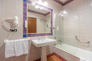 a bathroom with a sink and a tub and a mirror at Moon Dreams El Cortijo in Matalascañas