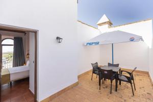 a room with a table and chairs and an umbrella at Moon Dreams El Cortijo in Matalascañas