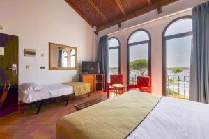 a bedroom with two beds and a tv and windows at Moon Dreams El Cortijo in Matalascañas
