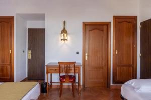a bedroom with a desk with a chair and a bed at Moon Dreams El Cortijo in Matalascañas