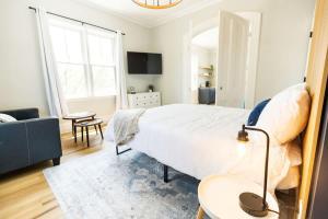 a bedroom with a large bed and a living room at Jennifer's Spa-Like Modern & Chic Broadway Retreat in Providence
