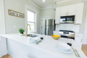 a kitchen with a white counter top and a sink at Jennifer's Spa-Like Modern & Chic Broadway Retreat in Providence