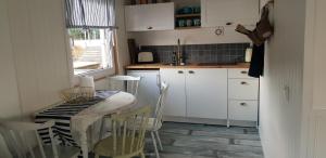 eine Küche mit Tisch, Stühlen und Spüle in der Unterkunft Green husbåt in Södertälje